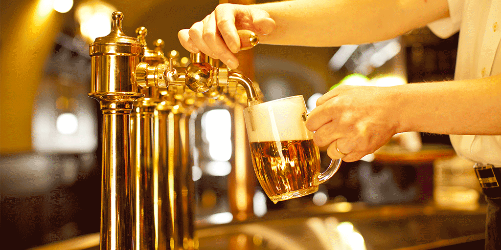 A bartender pours a perfect mug of beer with good head