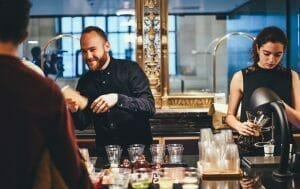 Professional and well trained male female bartenders serving cocktails