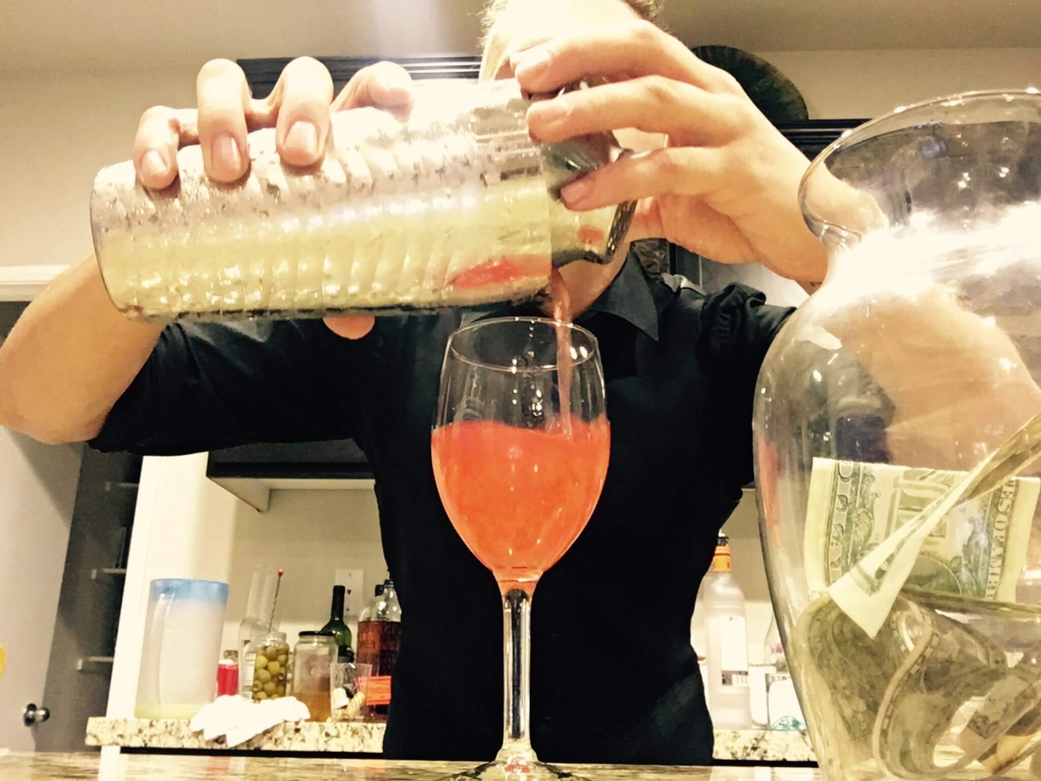A graduate from our Inland Empire Bartenders School mixes a drink