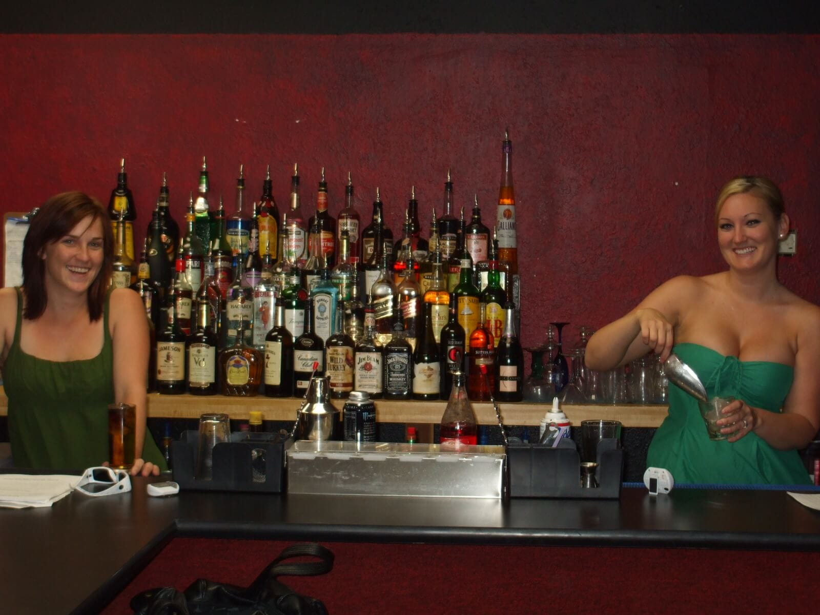 Two young women learn how to be a good bartender