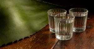 Three shots of Mezcal on the bar.